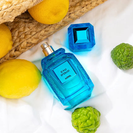 Ajmal Eau d’Oud Eau de Parfum 100ml displayed attractively among fresh lemons and greenery, emphasizing its refreshing and vibrant scent, perfect as both a MEN'S PERFUME and WOMEN PERFUME.