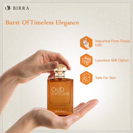 A hand holding the Oud Awsome perfume bottle, displaying the product with features like 'Imported From Dubai' and 'Luxurious Gift Option', showcasing its elegance.