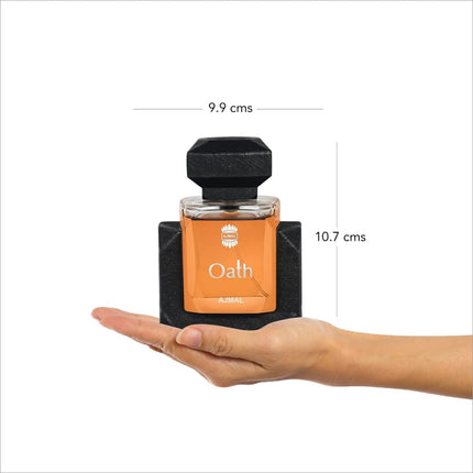 a hand holding an orange and black bottle