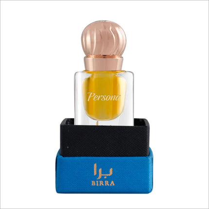 Clear glass perfume bottle featuring a golden-yellow fragrance, displayed in a black and blue box, with a rose gold cap and 'Persona' label.