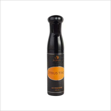 Display of Citrus Tinge 300ml room freshener spray among fresh citrus fruits, emphasizing its refreshing scent.