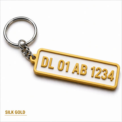 Gold-plated custom number plate keychain with raised lettering on white background for car enthusiasts