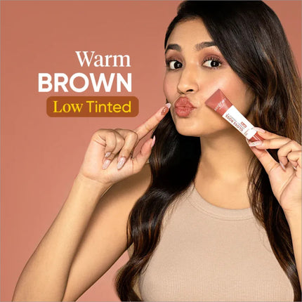Model applying Dot and Key Gloss Boss Vitamin C + E Lip Balm with SPF 30, highlighting its use as a daily moisturizing lip balm with SPF.