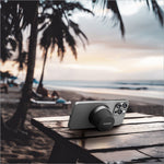 Silver smartphone held upright by black momax bs6 magnetic wireless speaker phone stand on wooden table