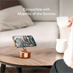 Rose gold momax kh20 electric magnetic phone stand with sleek cylindrical base and adjustable arm holding iphone