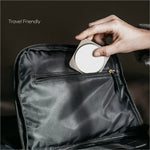 A sleek circular white wireless charging stand with metallic edges from momax q2.mag go 3-in-1 foldable charger