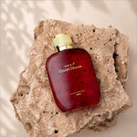 Deep red glass bottle of next golden dragon perfume with a gold-toned ribbed cap for skin care luxury scent
