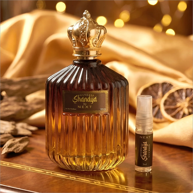 A luxurious amber glass perfume bottle with a golden crown stopper and travel spray for korean skin care use