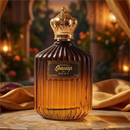 A luxurious amber glass perfume bottle with a golden crown cap labeled shanaya by next for korean skin care