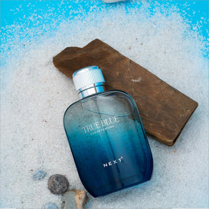 A sleek gradient blue glass bottle of true blue perfume by next designed for skin care and fragrance use 100ml