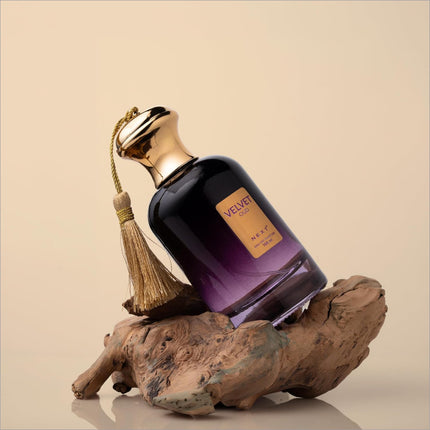 A luxurious dark purple glass perfume bottle with gold cap and tassel labeled velvet oud by nexy for oud eau use