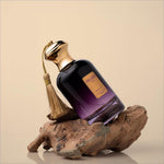 A luxurious dark purple glass perfume bottle with gold cap and tassel labeled velvet oud by nexy for oud eau use