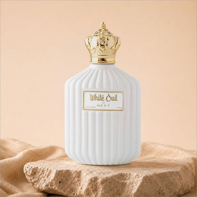 White oud perfume in a white ceramic bottle with gold crown cap and ribbed texture for skin care use