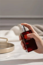 A sleek rectangular red glass perfume bottle with silver spray nozzle from next z plus korean skin care collection