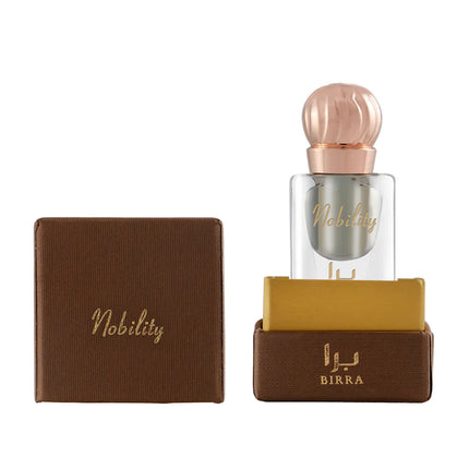 Nobility 6ML attar by BIRRA displayed in a clear glass bottle with a rose gold cap, accompanied by its sophisticated brown packaging showcasing gold details.