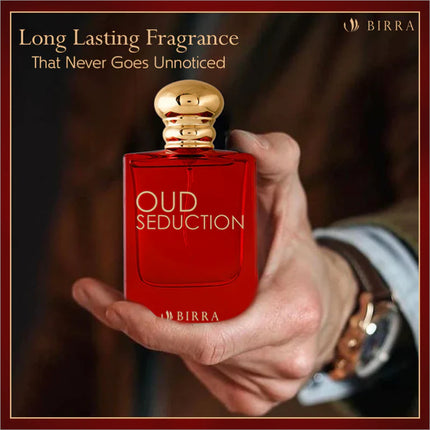A hand holding the Oud Seduction EDP bottle, emphasizing its long-lasting fragrance with a blurred, elegant background.