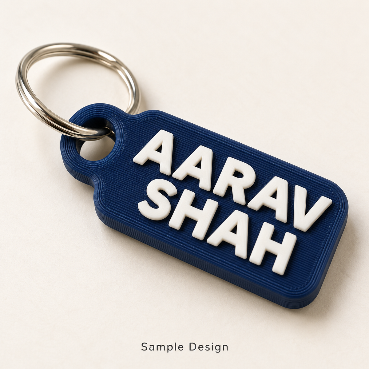 Rubnic sample navy two-line 3D printed name keychain with AARAV SHAH text