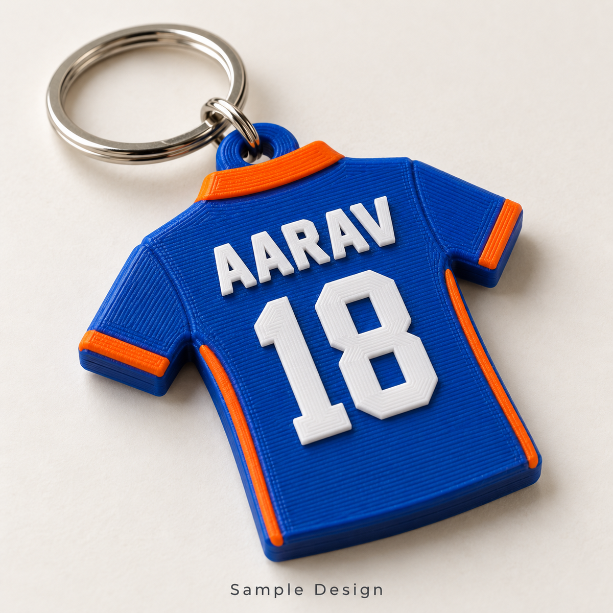 Rubnic sample blue and orange 3D printed cricket jersey keychain with name AARAV and number 18