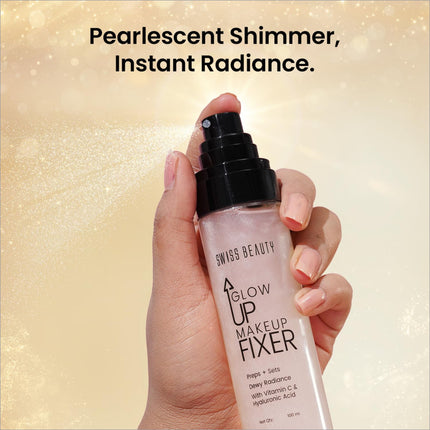 A translucent pink bottle of Swiss Beauty Glow Up makeup fixer with black spray nozzle and dewy radiance formula label