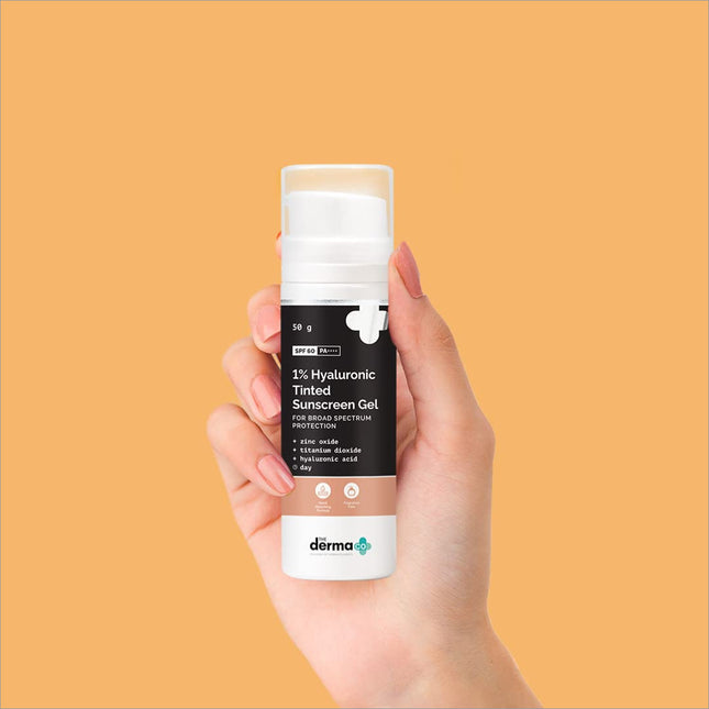 a hand holding a bottle of deodorant on an orange background