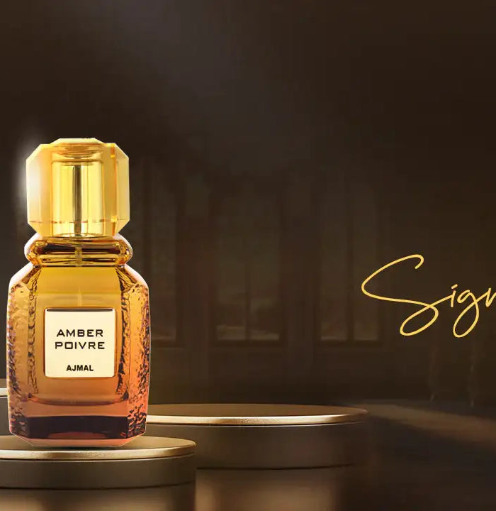 Two elegant perfume bottles from the signature series by ajmal, one in sleek black glass with a matching cap and label, the other in amber-tinted glass with a golden cap and label.