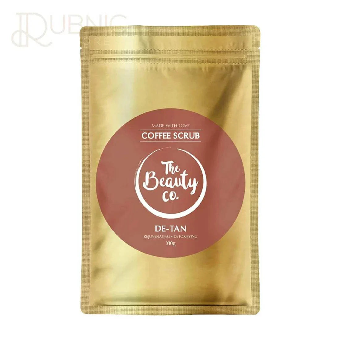 The Beauty Co. De-tan Coffee Face & Body Scrub 100g packaging showing detoxifying and rejuvenating properties for removing tan and restoring skin tone